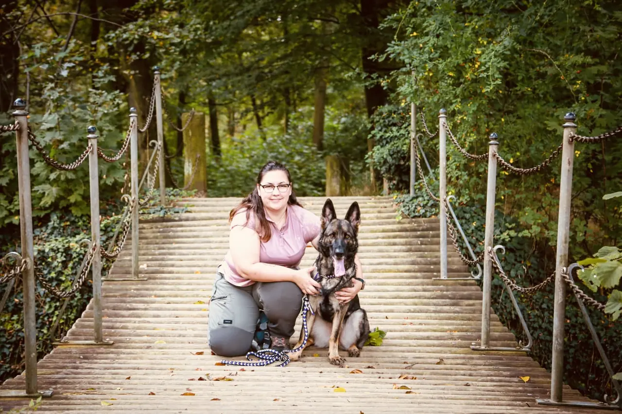 Carmen Sauer mit ihrem Schäferhund auf einer Brücke im Wald